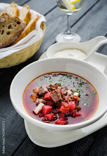 Homemade borsch with meat and sour cream.