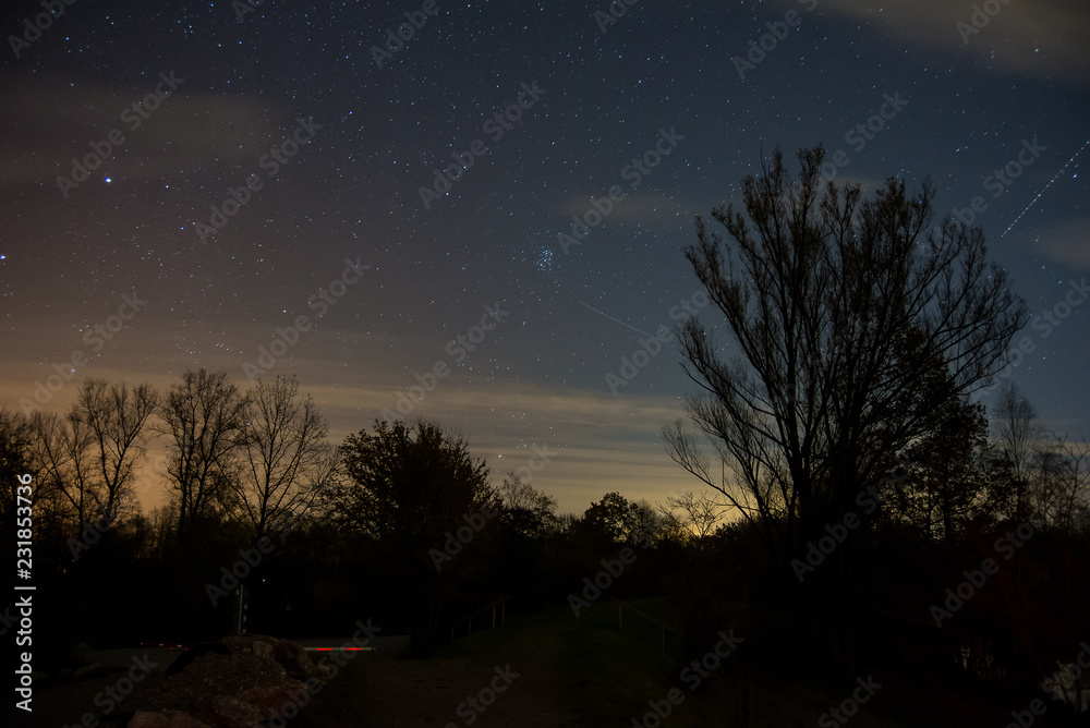 View of the stars aldebaran,hyadun I and hyadun II in the constellation of taurus over the eastern sky in Southern Germany with light pollution from a nearby village View of the stars aldebaran,hyadun I and hyadun II in the constellation of taurus over the eastern sky in Southern Germany with light pollution from a nearby village