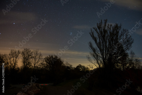 View of the stars aldebaran,hyadun I and hyadun II in the constellation of taurus over the eastern sky in Southern Germany with light pollution from a nearby village