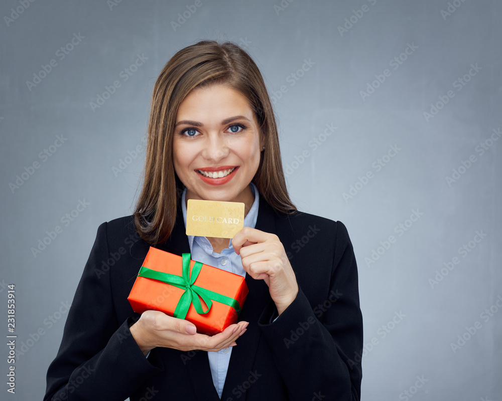 Happy smiling girl in business suit holding credit card and gift box.