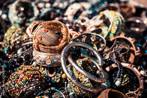 Many beautiful bracelets made of silver, copper, steel and gold. Decorated with precious and semiprecious stones. Vintage accessories. Bracelets from colorful beads. They lie in the store for sale. photo