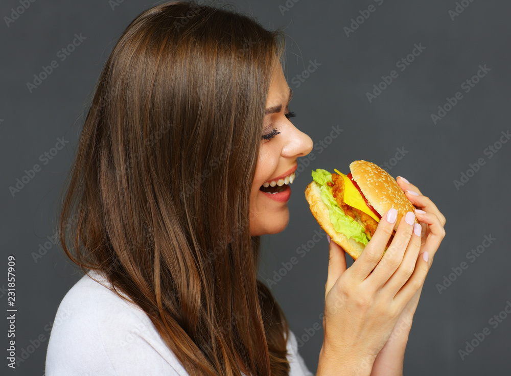 Smiling woman eat fast food burger.