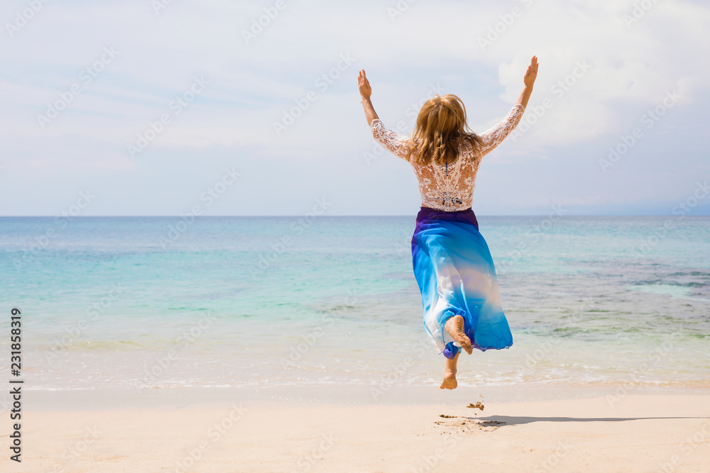 Carefree and happy woman jumping on the beach Carefree and happy woman jumping on the beach