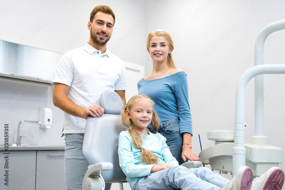 Fototapeta premium happy young family looking at camera at dentist office