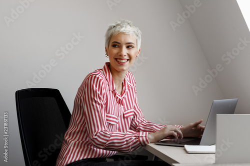 Portrait of beautiful smiling short-haired platinum blonde businesswoman.