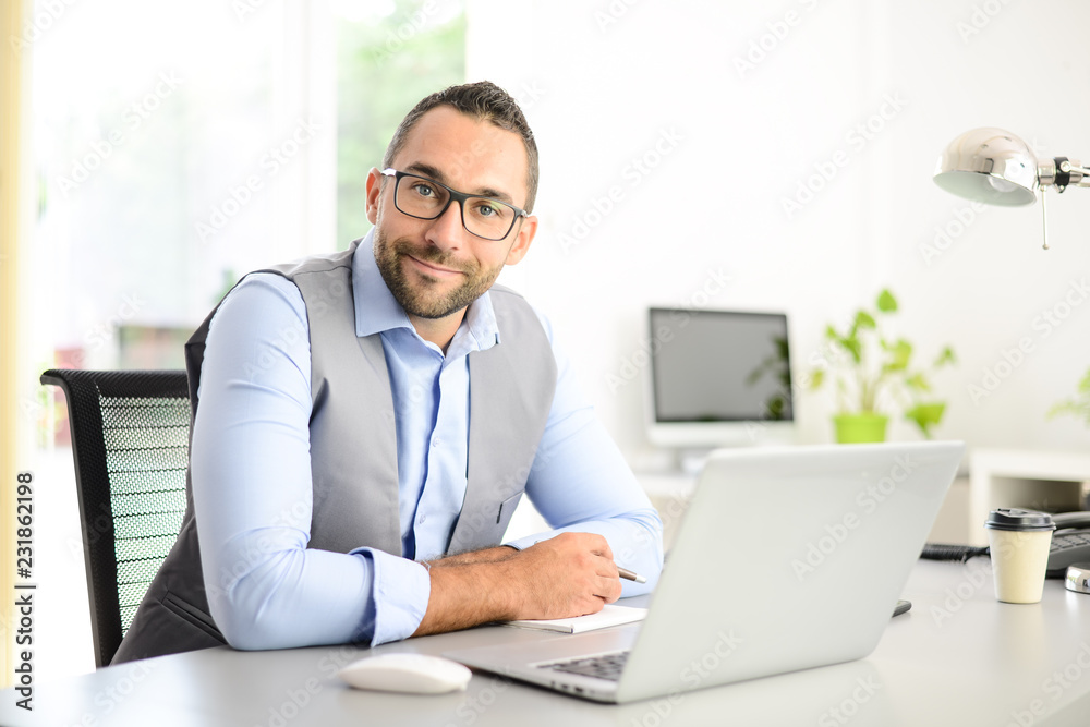 portrait of handsome trendy casual mid age business man in office desk with laptop computer portrait of handsome trendy casual mid age business man in office desk with laptop computer