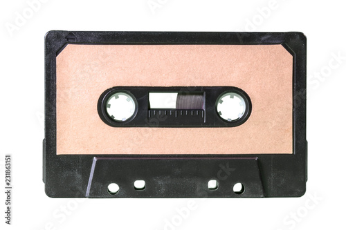 An old vintage cassette tape from the 1980s (obsolete music technology). Warm beige label, black plastic body, isolated on white.