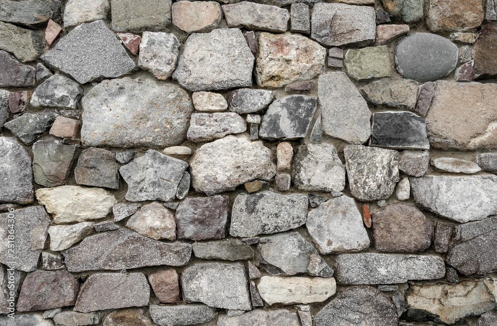 Texture of old stone wall. Clearly visible cobblestones.