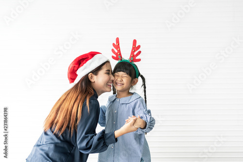 Asian mother and daughter happy and kiss together in livingroom at home in christmas day.