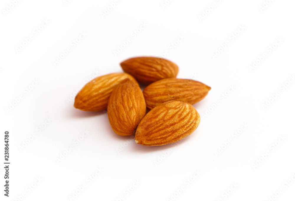A pile of almond nuts macro view, isolated on white background. A pile of almond nuts macro view, isolated on white background.