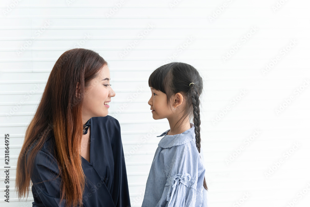 Asian mother and daughter looking eye together in livingroom at home. concept love and care. Asian mother and daughter looking eye together in livingroom at home. concept love and care.