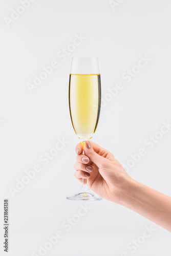 cropped shot of woman holding glass of champagne in hand isolated on white