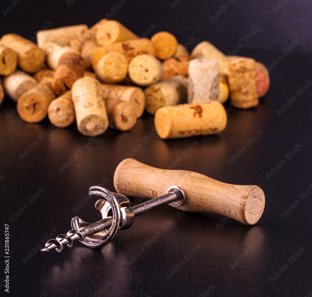 The wine corks and corkscrew on black  table