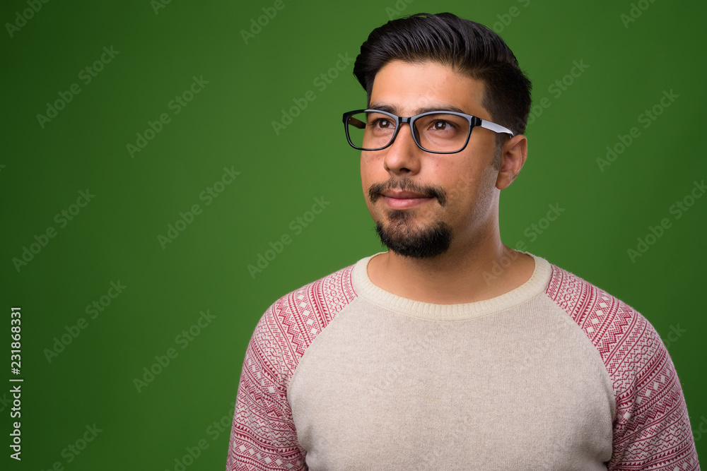 Fototapeta premium Young bearded Iranian man against green background