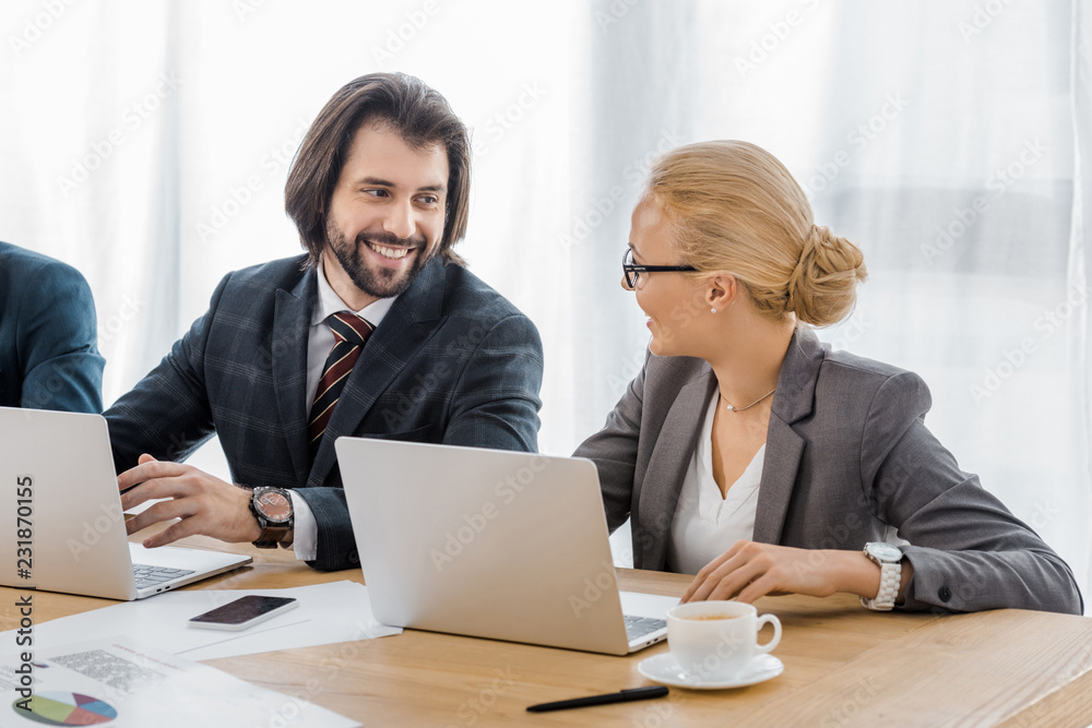 smiling business people talking at meeting in office smiling business people talking at meeting in office
