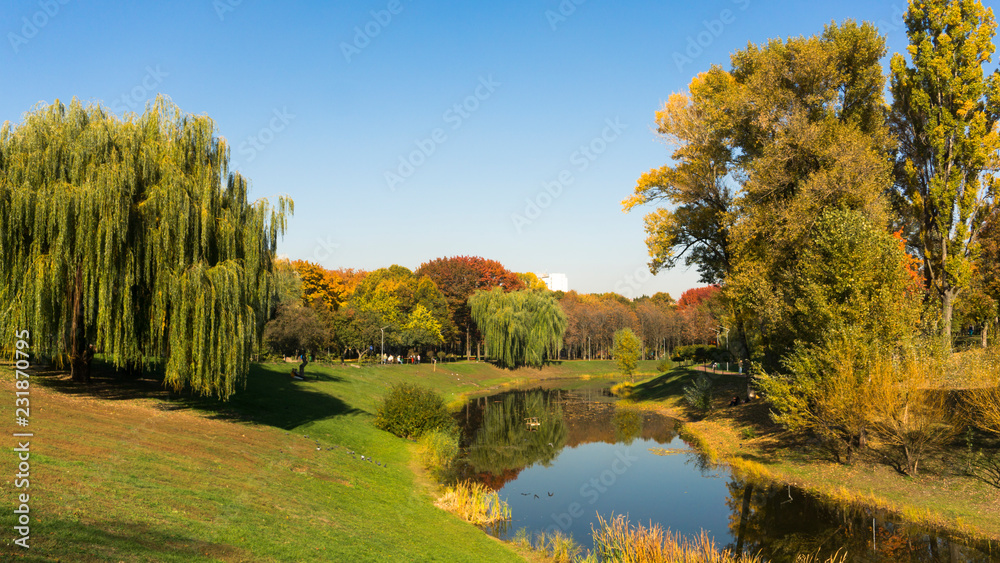 Beautiful fall colors reflect off a pond. Autumn park Beautiful fall colors reflect off a pond. Autumn park