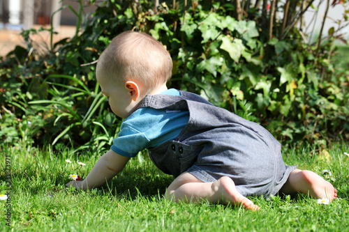 Kleines Kind spielt barfuss im Gras