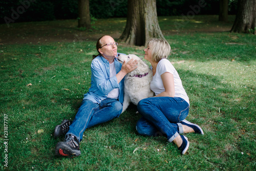 Adult couple sitting on the grass with a white hash