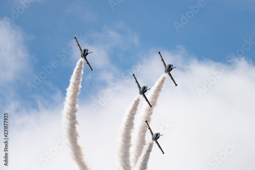 Low angle view of airshow in cloudy sky