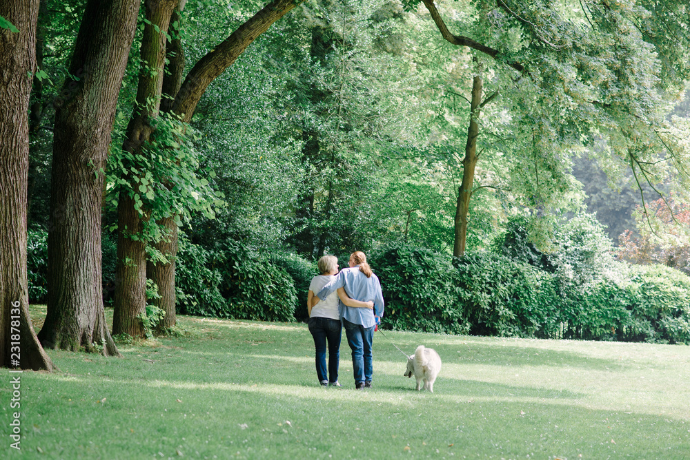 Adult couple walking on the grass with a white hash
