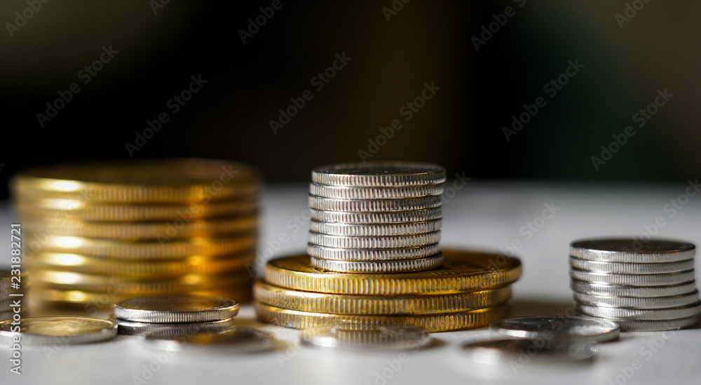 Macro shot detail of golden and silver color coin stacks on dark background with copy space for text. Business and finance growth, saving money, investment and interest concept. Macro shot detail of golden and silver color coin stacks on dark background with copy space for text. Business and finance growth, saving money, investment and interest concept.