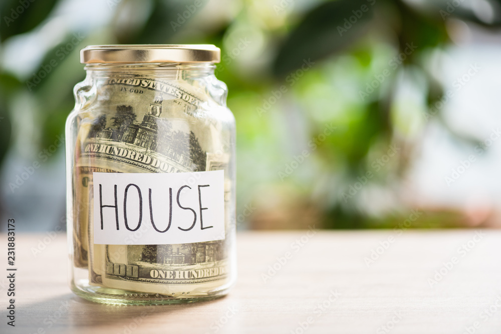 close-up view of glass jar with dollar banknotes and inscription house close-up view of glass jar with dollar banknotes and inscription house