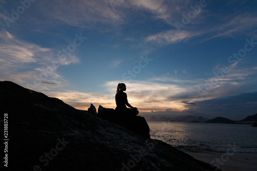mulher meditando na praia  no p  r do sol