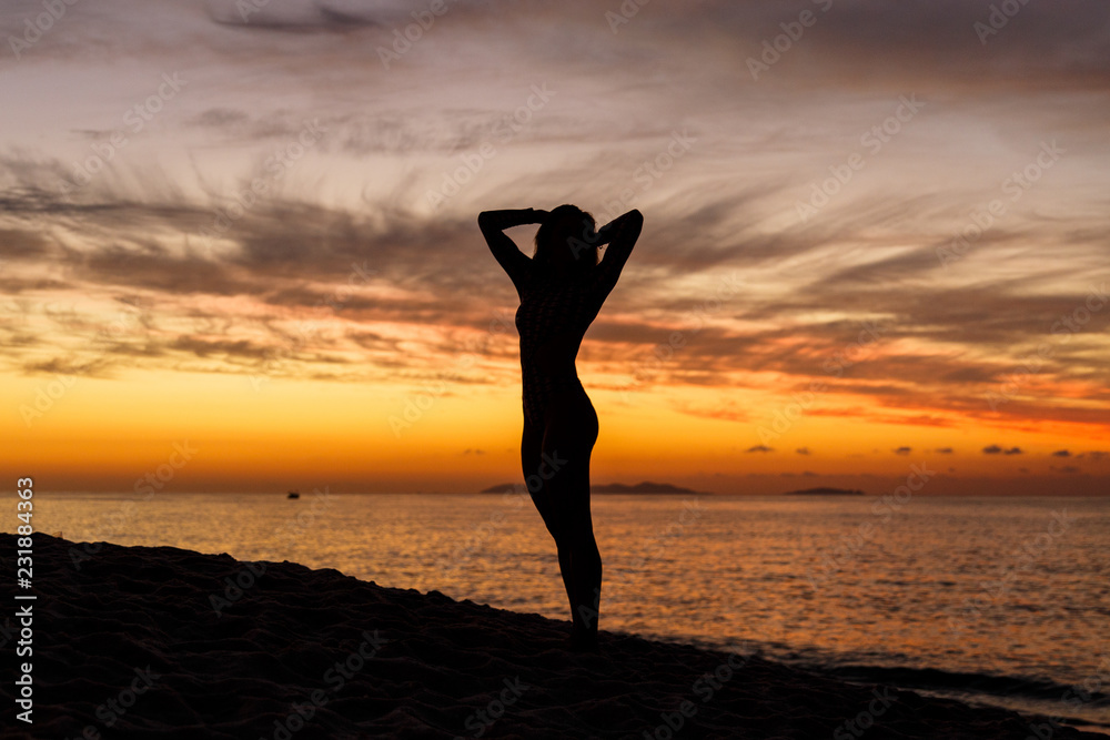 silhueta de mulher contemplando o nascer do sol, na praia de itaipuaçu em niterói