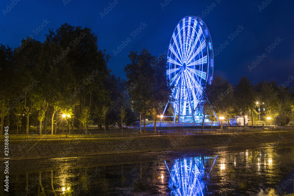 A bright luminous observation wheel on the embankment of the River Uvod in Ivanovo.