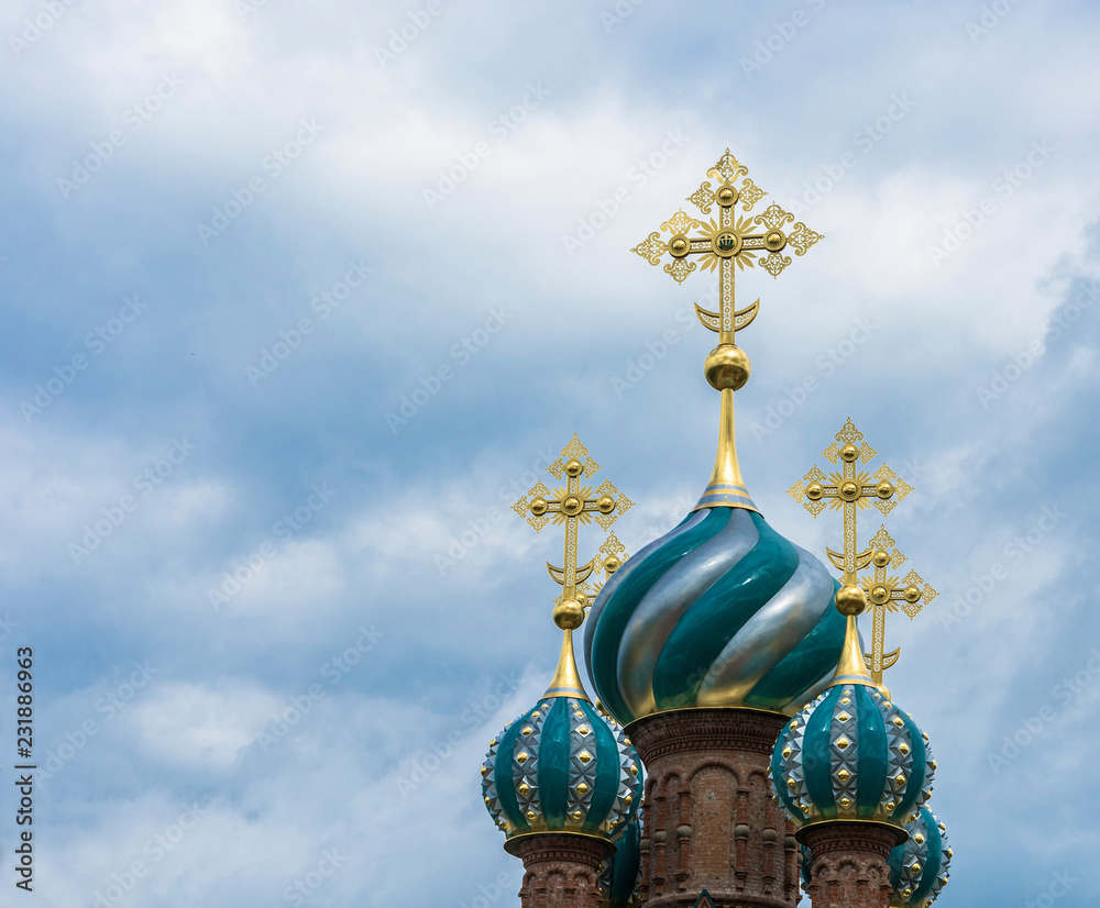 Beautiful church domes with gold crosses against a cloudy sky.