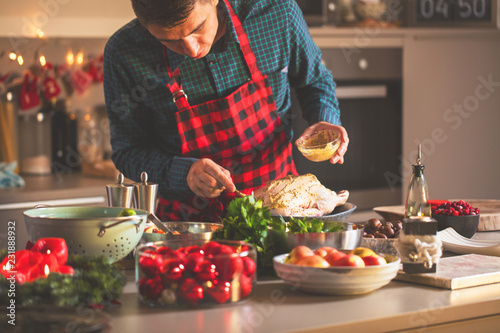 Man preparing delicious and healthy food in the home kitchen for christmas (Christmas Duck or Goose) photo