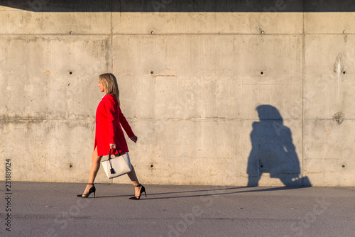 Blonde woman wearing red jacket walking on the street