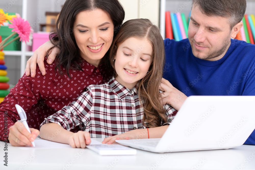 Portrait of parents and daughter using laptop in room Portrait of parents and daughter using laptop in room