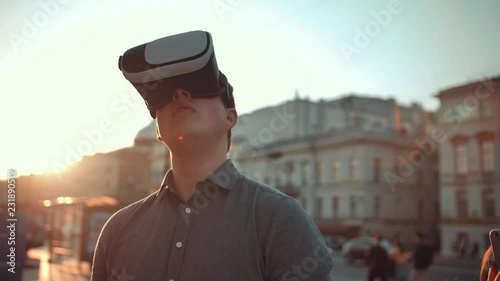 Attractive Guy and handsome girl in vr glasses in city crowded street trying to find something interesting additional information of this place with smartphone. Virtual reality concept. photo