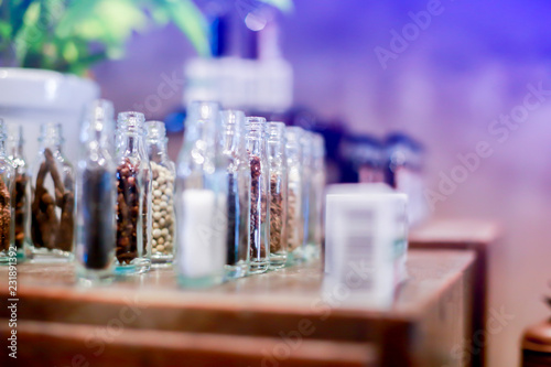 Ancient herb in glass jars on wooden table in Chinese or Thai herbal medicine shop.