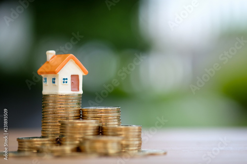 House model on top of stack of coins. Business and finance, Property investment and asset management, Fund, Loan, Mortgage, Inflation, Sale and tax rise and Saving money for buy or rent home concept.