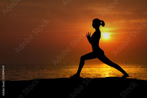 Fototapeta Naklejka Na Ścianę i Meble -  Silhouette of woman practicing yoga on the beach at sunset
