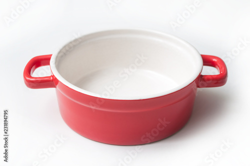 closeup of red ceramic saucepan on white background