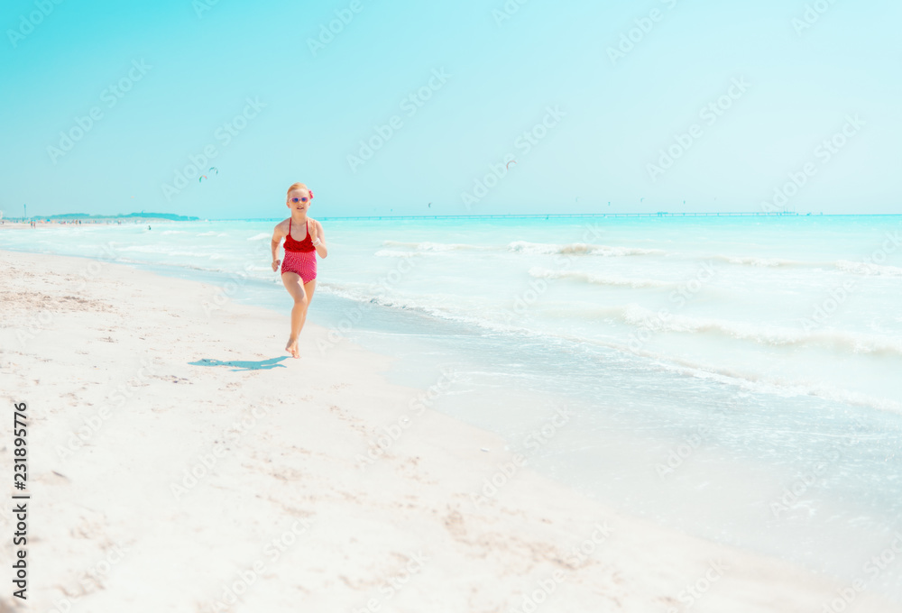 modern girl in red swimwear on seashore jogging modern girl in red swimwear on seashore jogging
