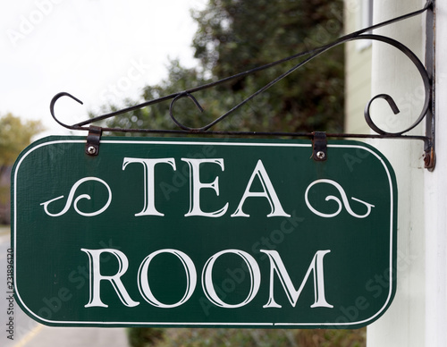 White on green TEA ROOM sign attached to metal bracket on building.  photo