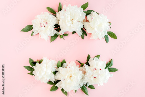 Frame wreath of white peony flowers with space for text on pink background. Peony texture. Flat lay, top view. 