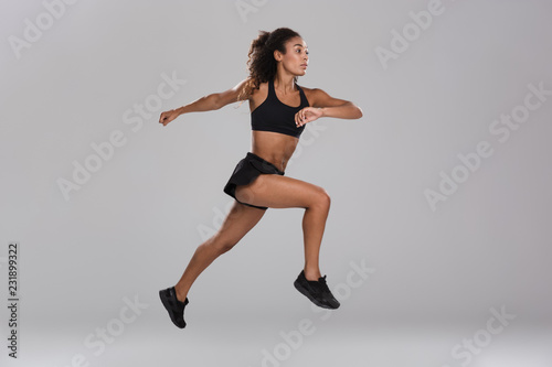 Amazing beautiful strong sports woman jumping isolated.