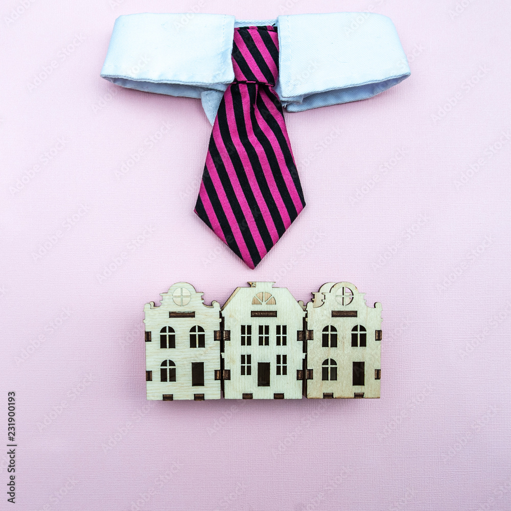 Fototapeta premium Mayor, the intelligentsia of the city concept. A tie with a white collar above the toy houses of the city, a symbol of management. View from above, flat lay