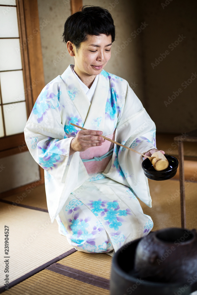 Japanese woman wearing traditional white kimono with blue floral pattern  kneeling on tatami mat during tea ceremony. Stock Photo | Adobe Stock