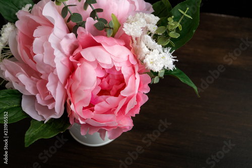 Fototapeta Naklejka Na Ścianę i Meble -  Pink artificial peonies on a black background.
