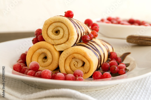 Homemade pancakes twisted with chocolate on a white plate.