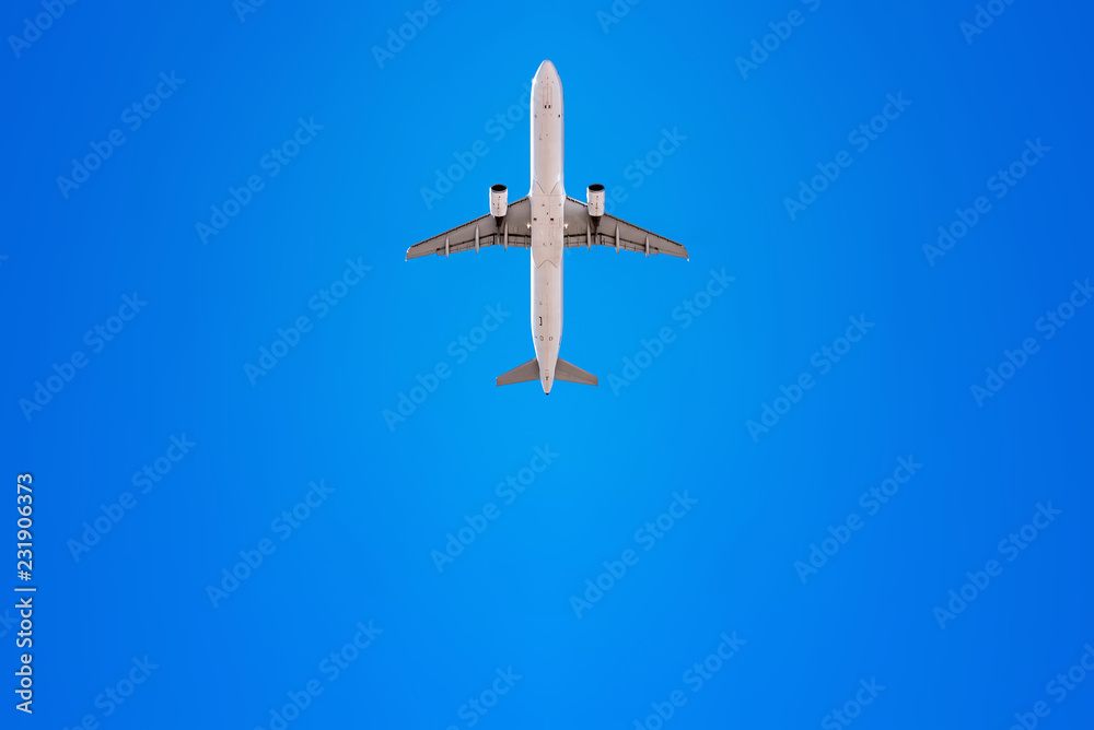 Naklejka premium airplane flies into a perfect blue sky