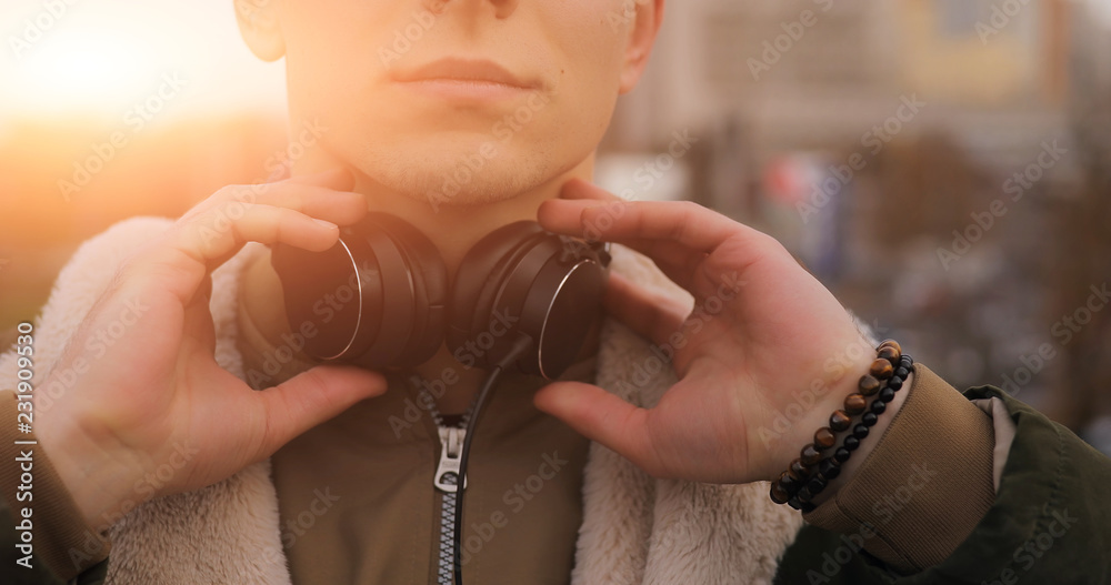 Man with headphones in urban sunlight