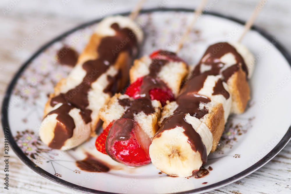 Fruit and cake skewers with melted chocolate Fruit and cake skewers with melted chocolate