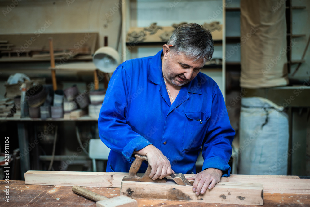 carpenter working in workshop, a worker planing a tree with a planer carpenter working in workshop, a worker planing a tree with a planer
